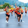 Group of runners in colorful attire energetically participating in a marathon outdoors.