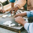 People playing dominoes on a street side table in São Paulo, capturing everyday life.